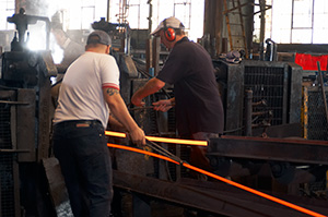 men-feeding-steel-into-press